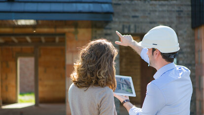 An architect shows the 3D model of the house to a client.