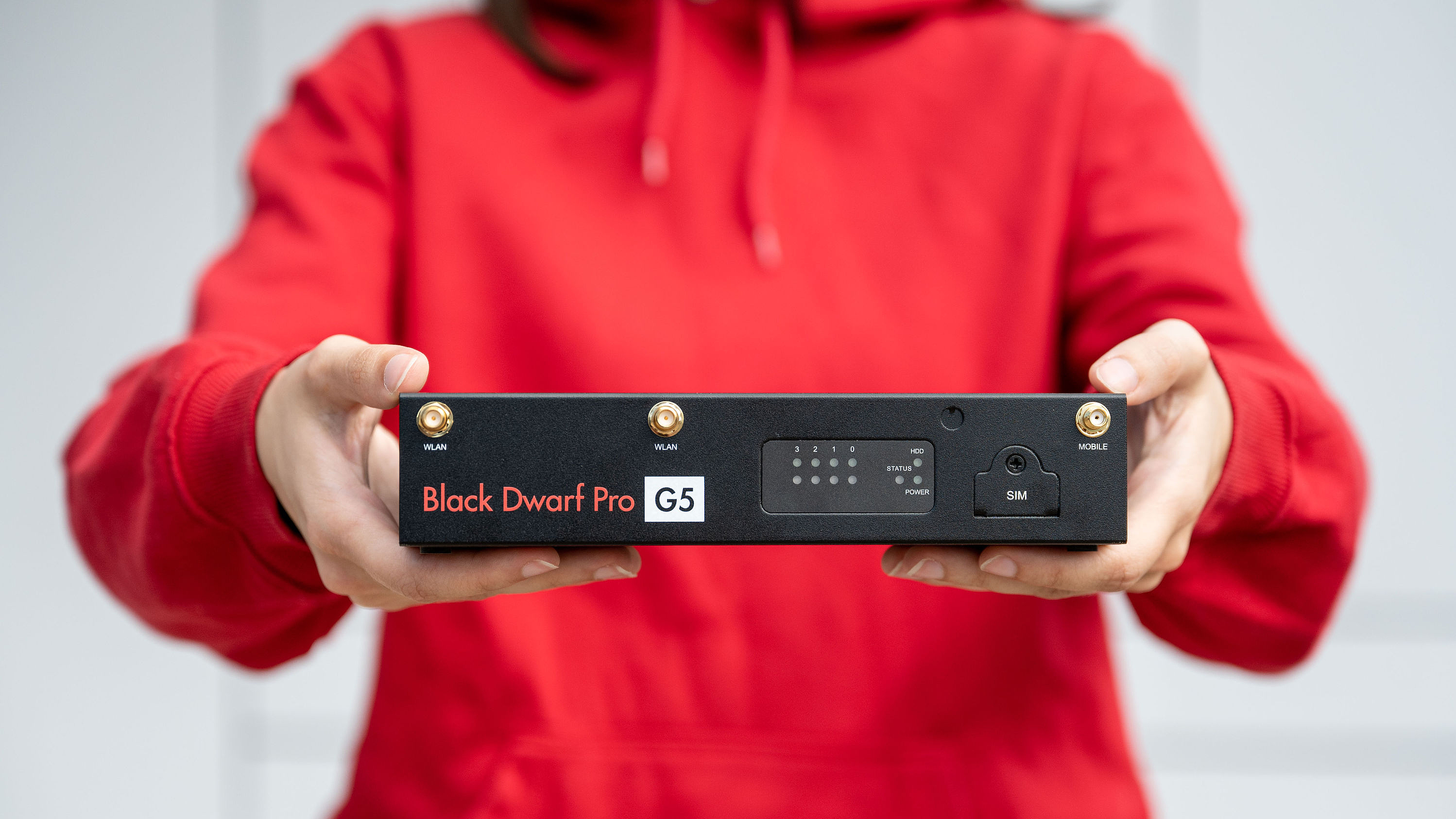 Eine Person hält eine UTM-Firewall von Securepoint ins Bild