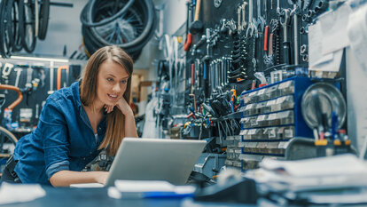IT-Sicherheit für Werkstätten Eine Handwerkerin kontrolliert ihren Warenbestand am Laptop.