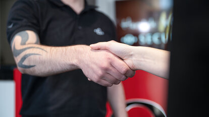 Two people shake hands.