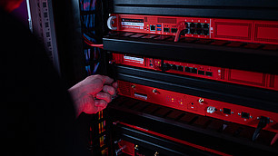 Ein Techniker schraubt eine Securepoint UTM-Firewall in ein Racksystem