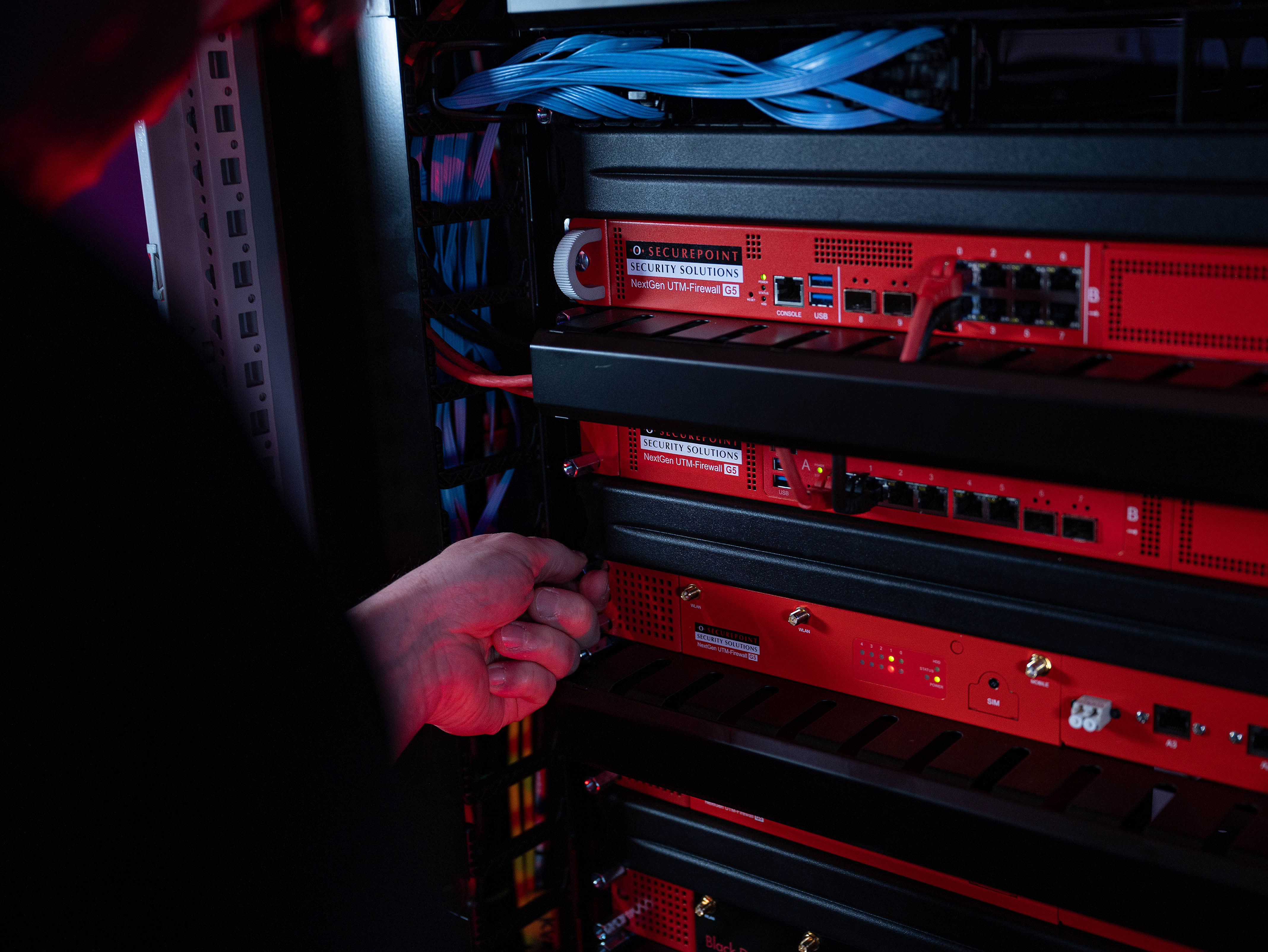 Securepoint UTM-Firewalls lassen sich einfach installieren Ein Techniker schraubt eine Securepoint UTM-Firewall in ein Racksystem