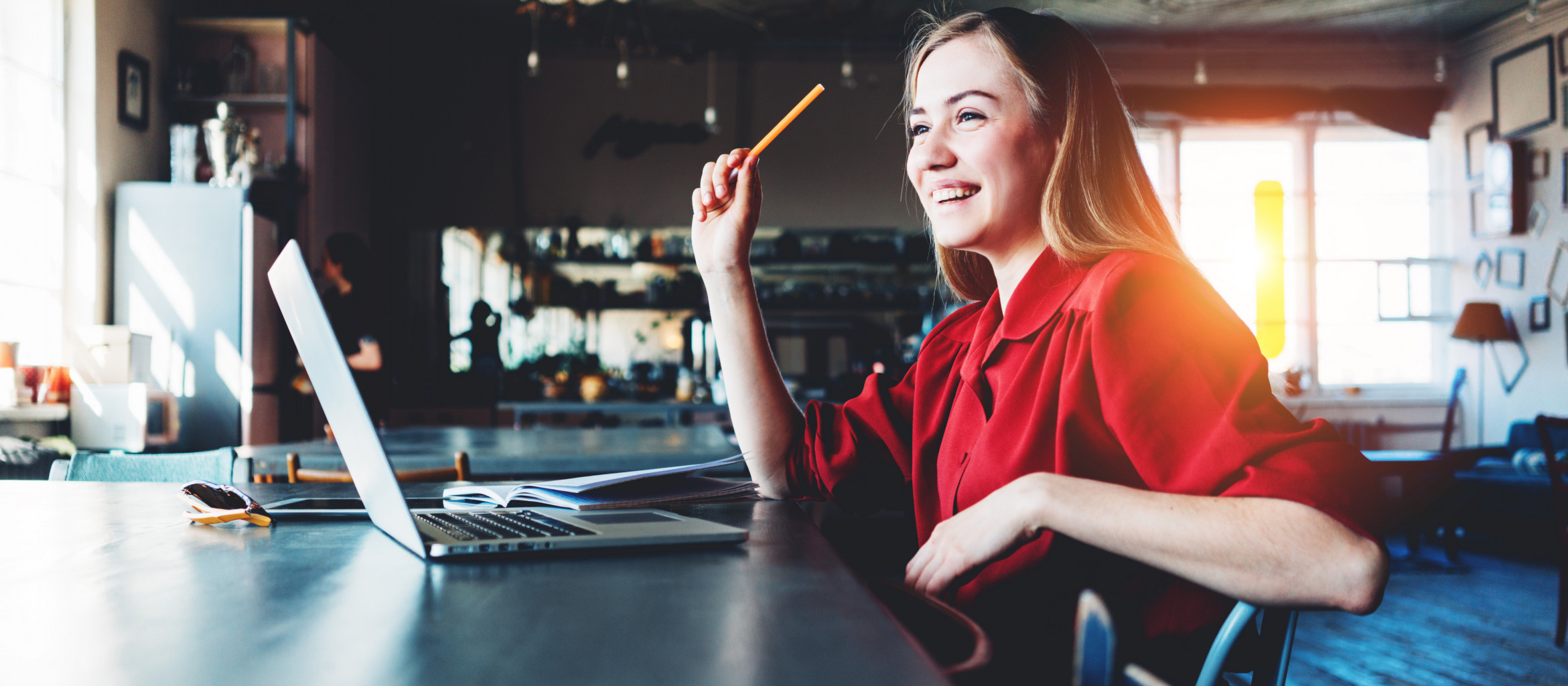 Frau mit Stift in der Hand vor einem Laptop